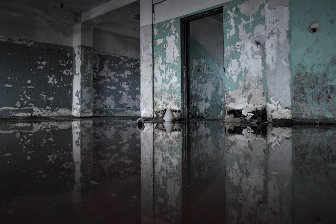 Water-damaged interior room with standing water and restoration context